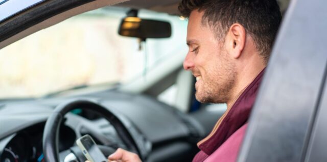 Conducteur installant une alarme dans sa voiture garée.